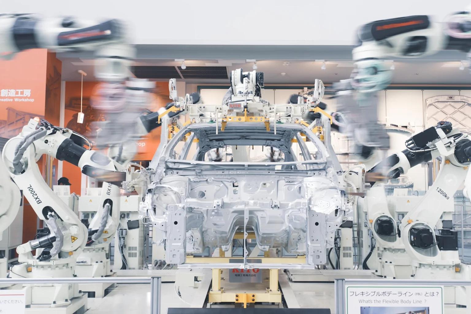 Robot arms positioned around a vehicle body assembly fixture