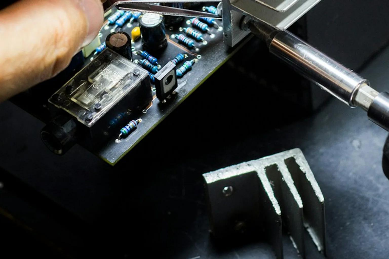Technician assembling components on an electronics board