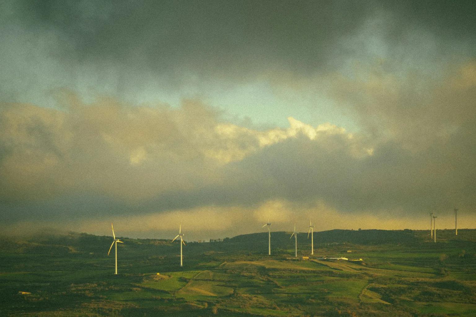 Wind turbines spread across a rolling landscape