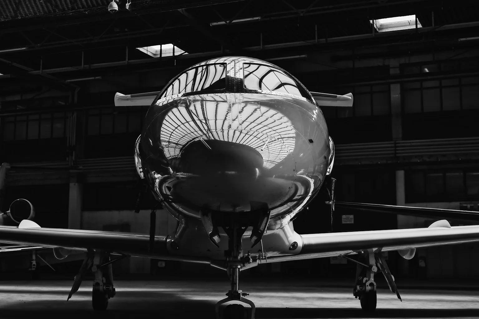 Business jet viewed head-on inside an aircraft hangar